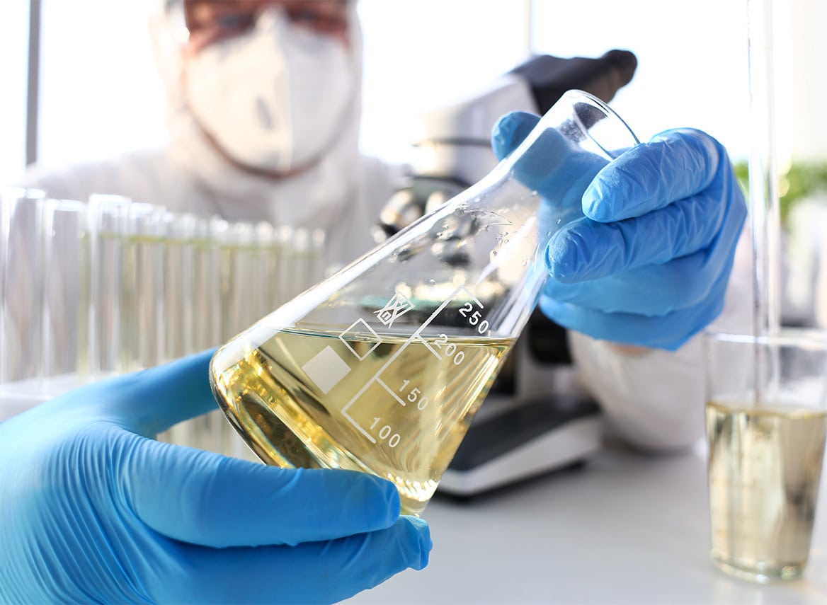 scientist with beaker filled with chemical